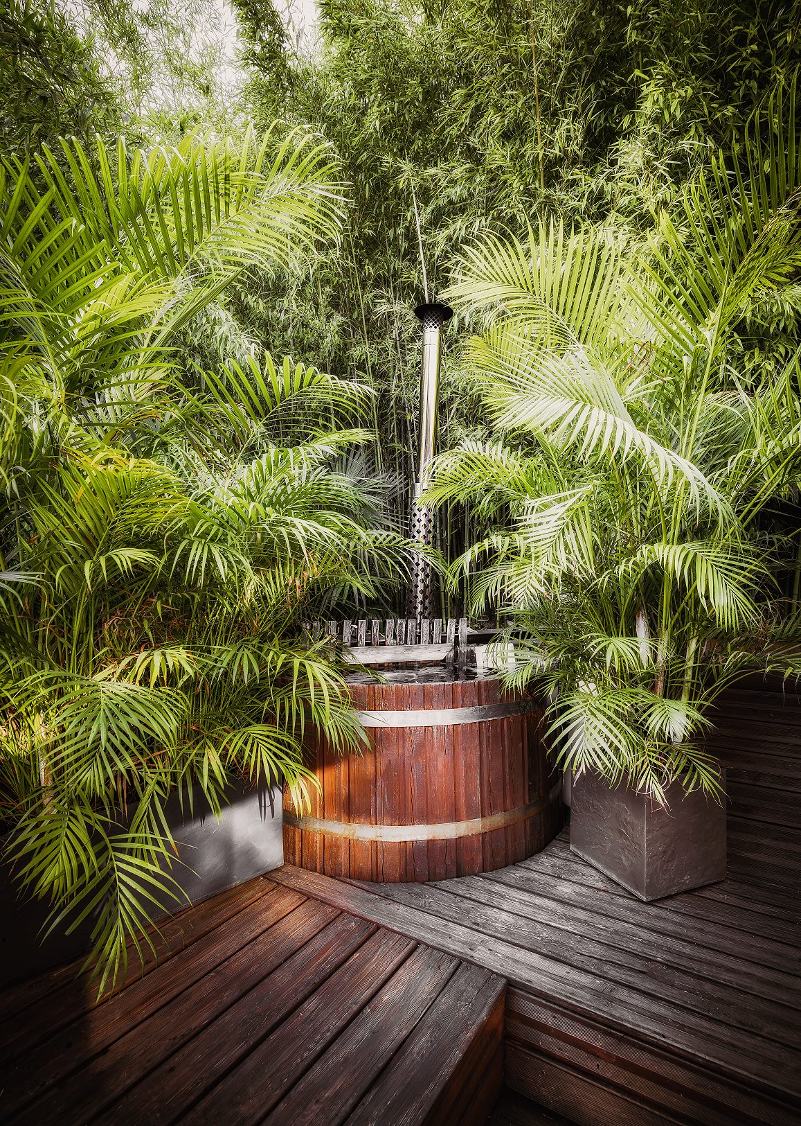Le bain nordique en bois entouré de palmiers