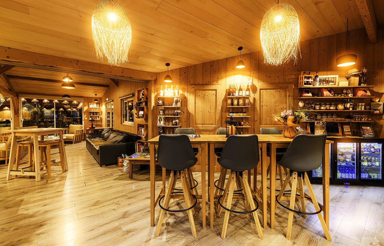 L'accueil et son bar tout en bois, sous les suspensions en osier