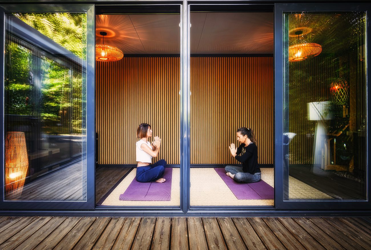 La salle de yoga vitrée, vue depuis la terrasse en bois